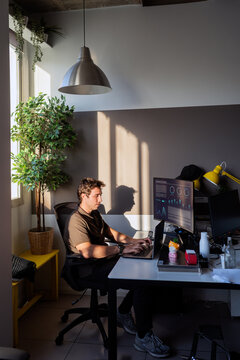Man working on laptop and computer in modern office