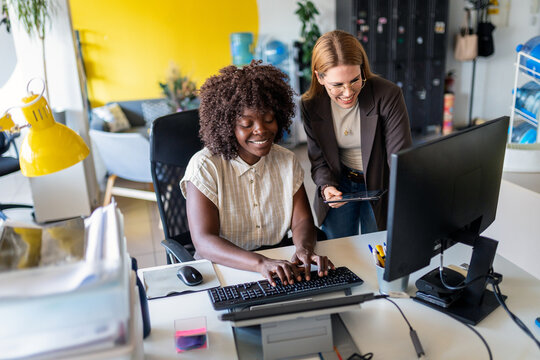 Business women collaborating on computer in office