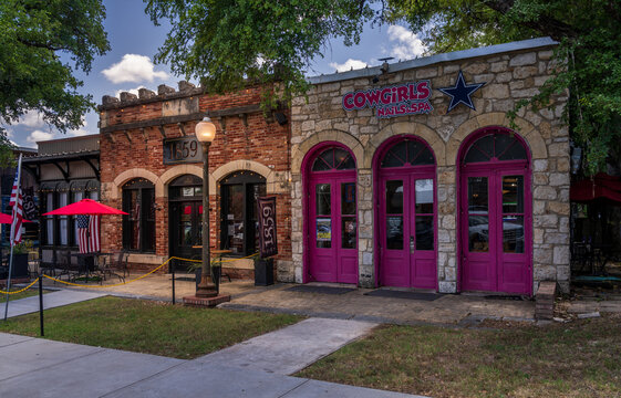Salado, TX - 10 July 2026: Exterior view of 1859 Tavern and Cowgirls Nail and Spa featuring stone facades and historic architecture on Main Street