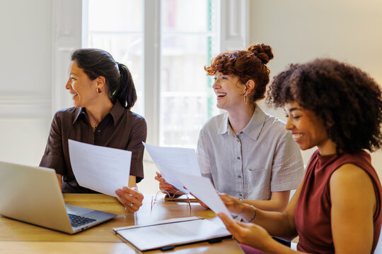 Female professionals collaborating and smiling during office meeting
