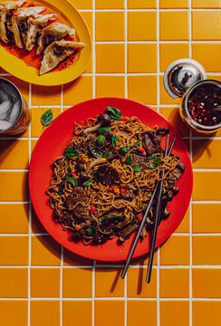 Beef stir fry noodles with side of dumplings