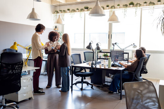 Diverse colleagues collaborating together in modern office space
