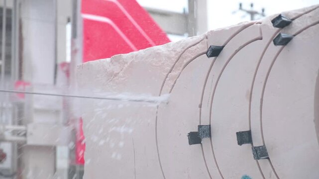Heavy machinery cutting large marble block in natural stone factory production line