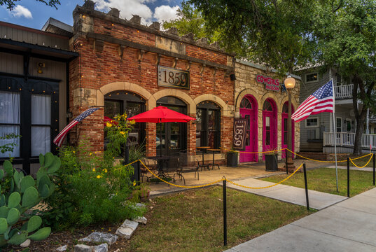 Salado, TX - 10 July 2026: Exterior view of 1859 Tavern and Cowgirls Nail and Spa featuring stone facades and historic architecture on Main Street