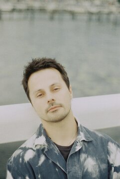 Man In Patterned Shirt By Water
