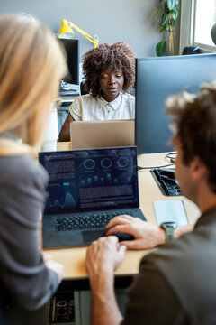 Coworkers collaborating on business data in office