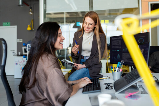 Coworkers collaborating and smiling in office