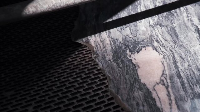 Heavy machinery cutting large marble block in natural stone factory production line