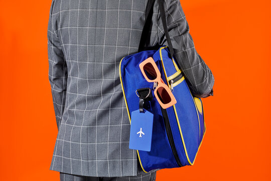 a man carrying a travel bag marked by a plane luggage tag
