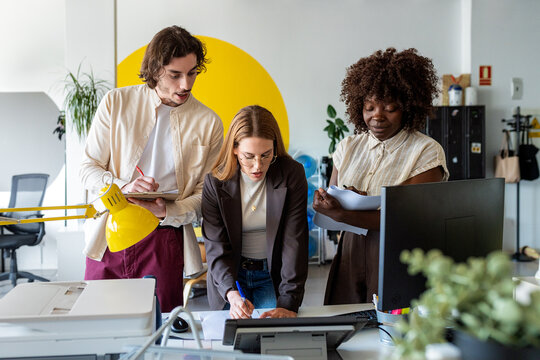 Diverse startup team collaborating on project in modern office