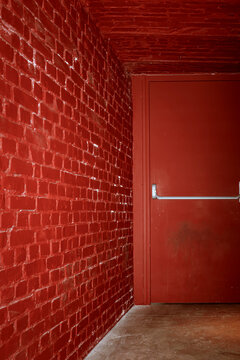 Bright Red Wall and Door in a Narrow Hallway