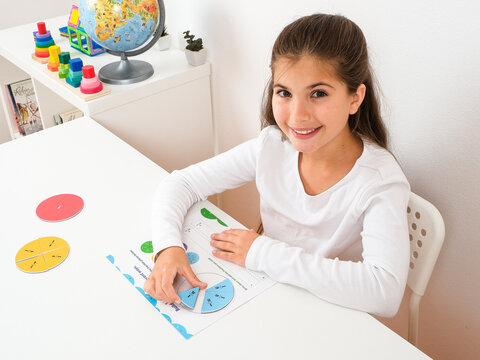 Elementary School Girl Learning Math Fractions Using Colorful Educational Tools
