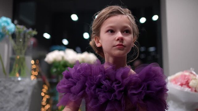 Thoughtful little girl in a ruffled dress during a special occasion. Special occasion concept.