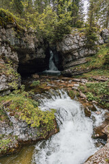 Rushing Waterfall Cascading Through a Rocky Mountain Ravine © Edgars