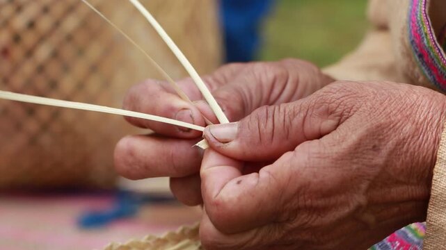 Close-up of an elderly Thai artisan skillfully weaving a handmade bamboo basket using traditional techniques in a rural village of Northern Thailand. The image highlights sustainable craftsmanship, na