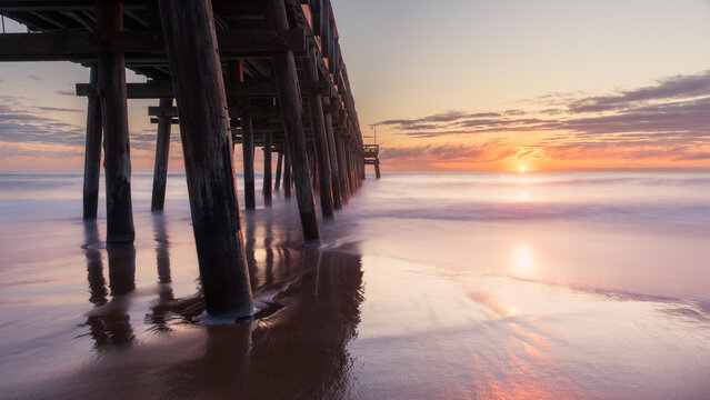 Sunrise view of the Sandbridge Fishing Pier in Virginia Beach, long exposure with smooth peaceful water