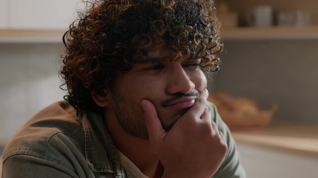Close up confused Indian man thinking problem solution at home kitchen puzzled Arabian male freelancer businessman searching answer deep thoughts creative planning idea pondering ideas indoors house