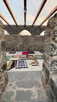 Walking into the stone prayer area with colorful rugs at historic Masjid Bani Anif.