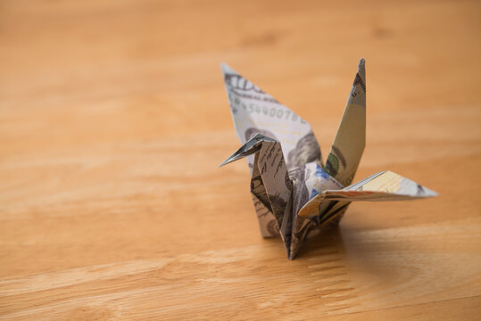 US dollar bill banknote flapping bird on wooden table background. Financial freedom through passive income, success wealth from investment, interest rate from bank account, dividend yield concept.