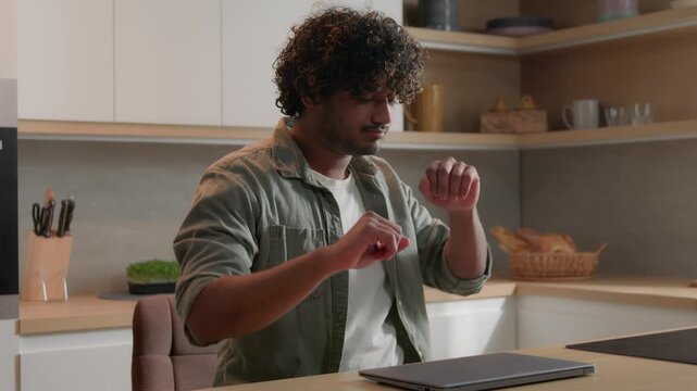 Happy Indian student man dancing finishing studying laptop at home cheerful freelancer businessman finished online work closing computer satisfied guy celebration in kitchen remote worker dance indoor