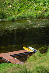Fototapeta premium Two sapboards lying on a wooden pontoon by the river.