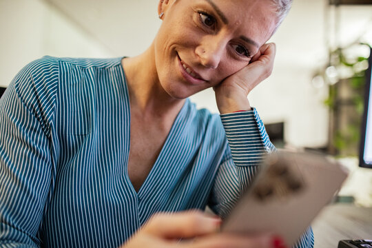 Smiling woman using smartphone at desk