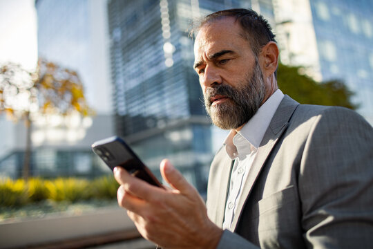 Businessman using smartphone outside office building