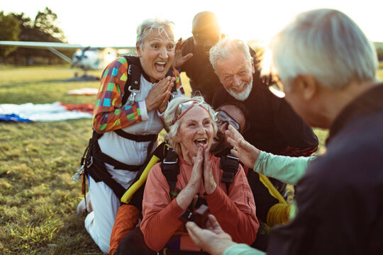 Senior friends celebrate skydiving proposal at airfield