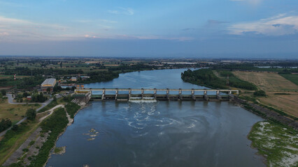 Fototapeta premium Isola Serafini Dam on Po river showing low water levels during a 2026 heatwave, reflecting climate change and drought conditions in Italys agricultural region