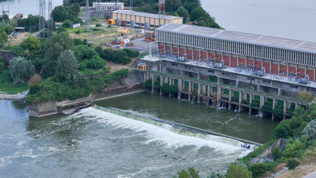 Isola Serafini Dam on the Po River features a large hydroelectric power plant. Displaying significantly reduced water flow over the weir