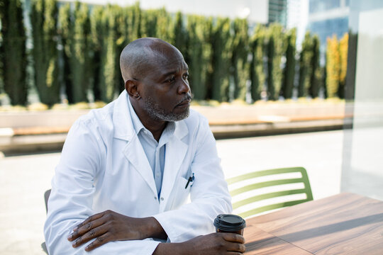 Doctor taking coffee break outdoors at hospital campus
