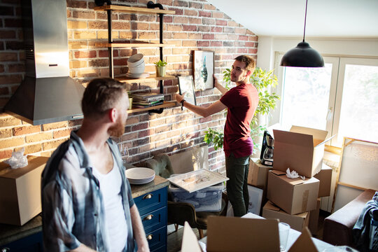 Two men unpacking and decorating a new apartment kitchen