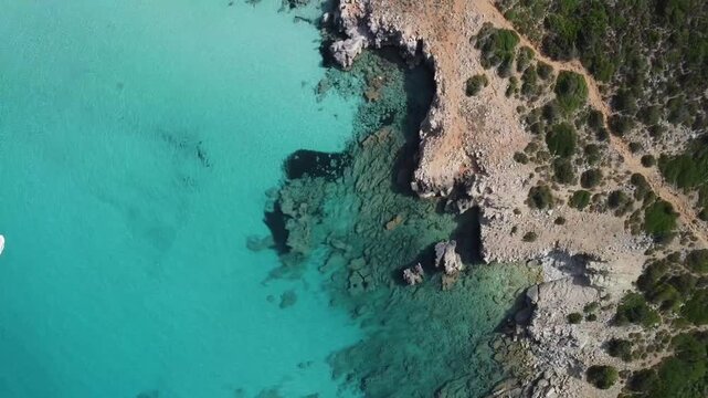 Aerial rotating view of crystal clear turquoise cove in Menorca, Spain