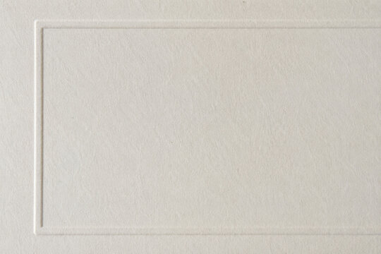 Elegant Cream Textured Background. A sophisticated pale canvas displaying a delicate raised rectangular border. Ideal for serene design projects, conveying purity and professionalism.