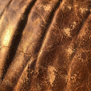 Close up of weathered rustic leather texture with rich brown tones and intricate natural creases ideal for vintage design projects and background patterns with a warm aged aesthetic