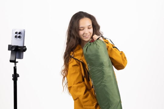 Happy traveler carrying hiking sleeping mat and backpack right at this exact mom