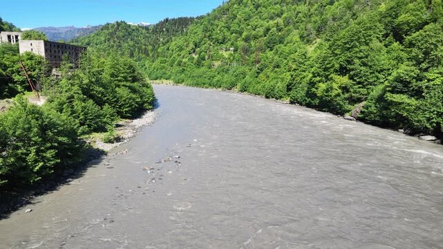 Aerial view of the Enguri river flowing through a lush mountain valley in Georgia, scenic nature landscape, travel and adventure destination