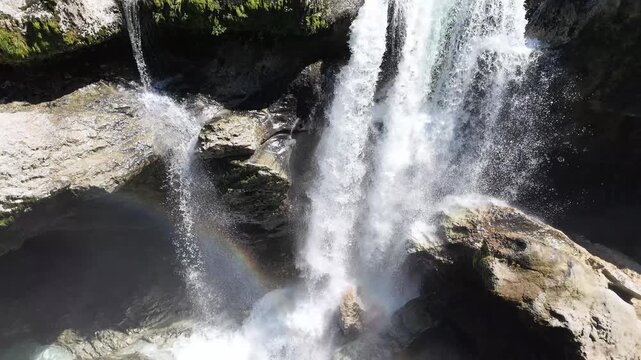 Aerial view of powerful waterfall at Martvili canyon in Georgia with mist and vibrant rainbow formation