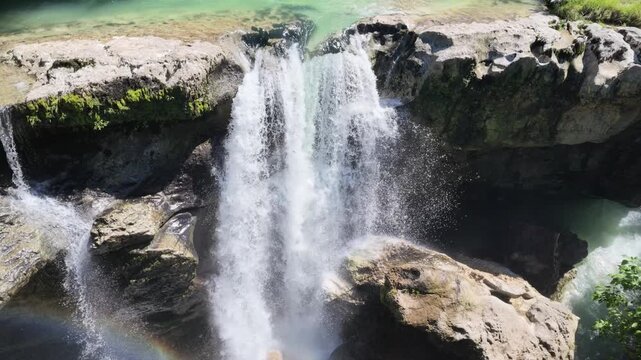 Aerial view of turquoise waterfall at Martvili canyon in Georgia with mist and small rainbow, nature travel scene