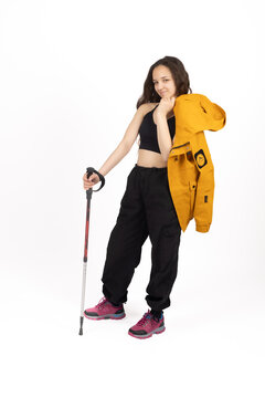 Confident traveler holding trekking poles standing proudly right at this exact m