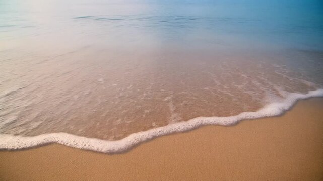 Gentle wave rolling onto sandy beach