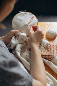 Hands embroidering traditional ukrainian cross stitch pattern