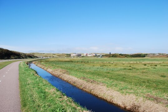 Peaceful canal running through green Dutch polder meadows
