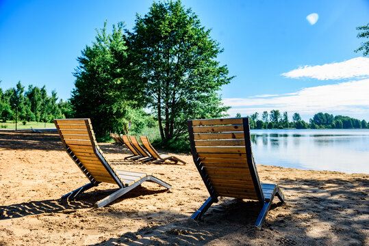 Sunbeds lakeside near residential complex.