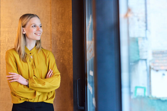 Portrait of a young  businesswoman woman posing in front of a wall in the office