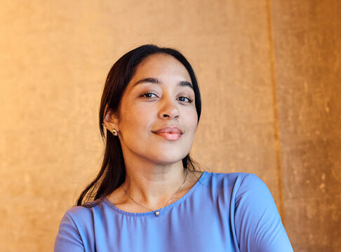 Portrait of a young  businesswoman woman posing in front of a wall in the office
