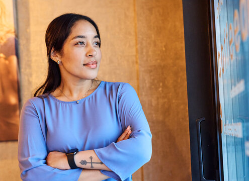 Portrait of a young  businesswoman woman posing in front of a wall in the office