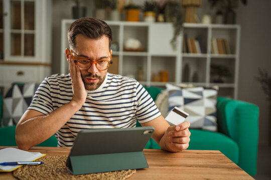 Man feeling overwhelmed with credit card debt during online shopping