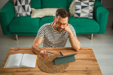 Man worrying about online payment debt using credit card