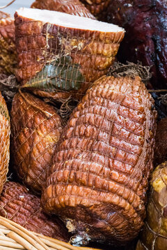 Fresh prepared smoked hams with spices on market stall